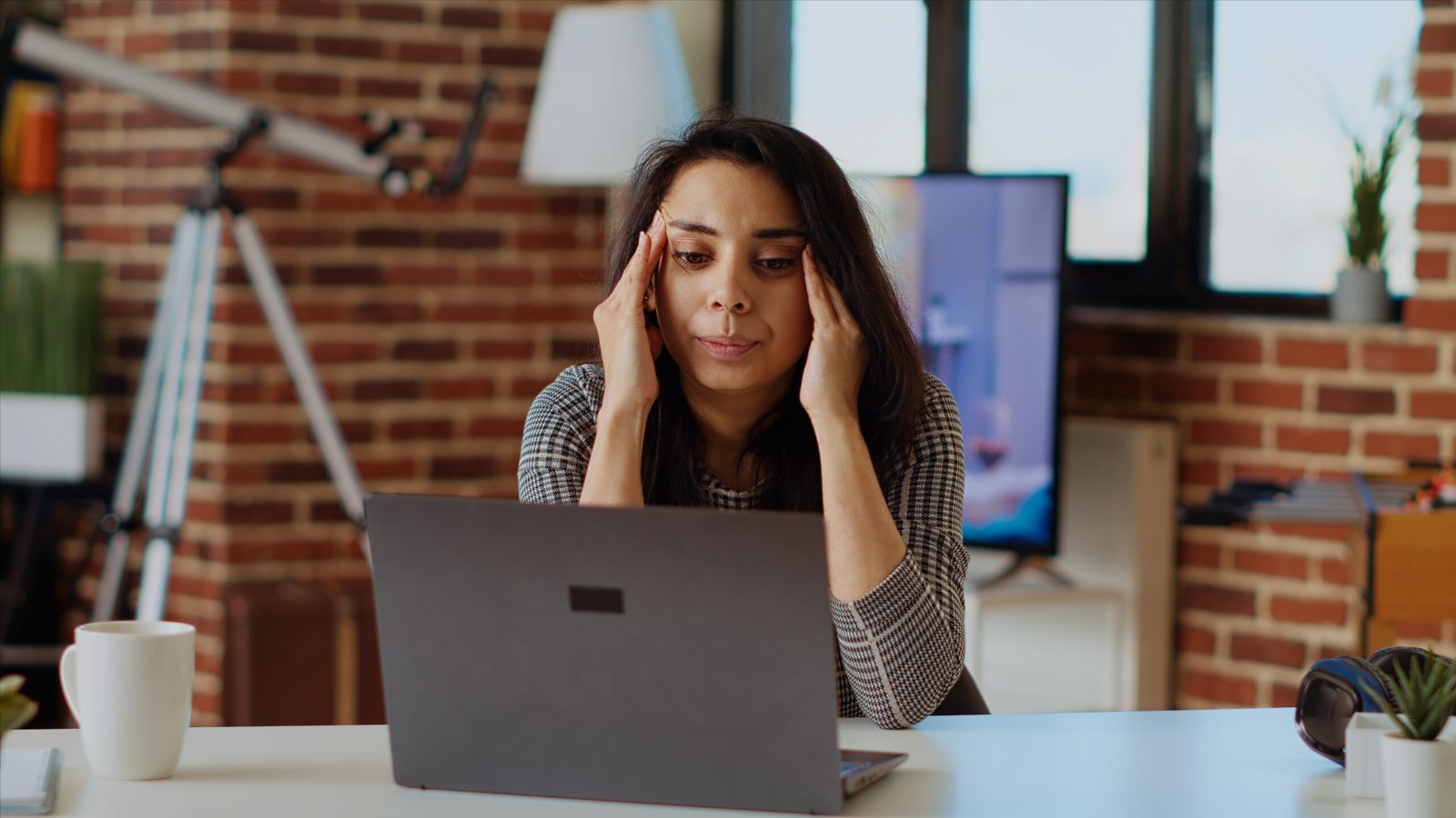 Exhausted freelancer suffering from sickness and stress while working on laptop